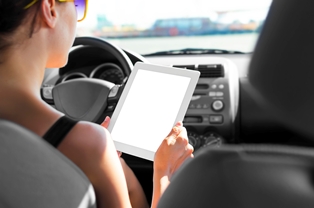 top driving distractions in america looking on tablet